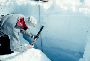 A researcher sampling ice on a glacier