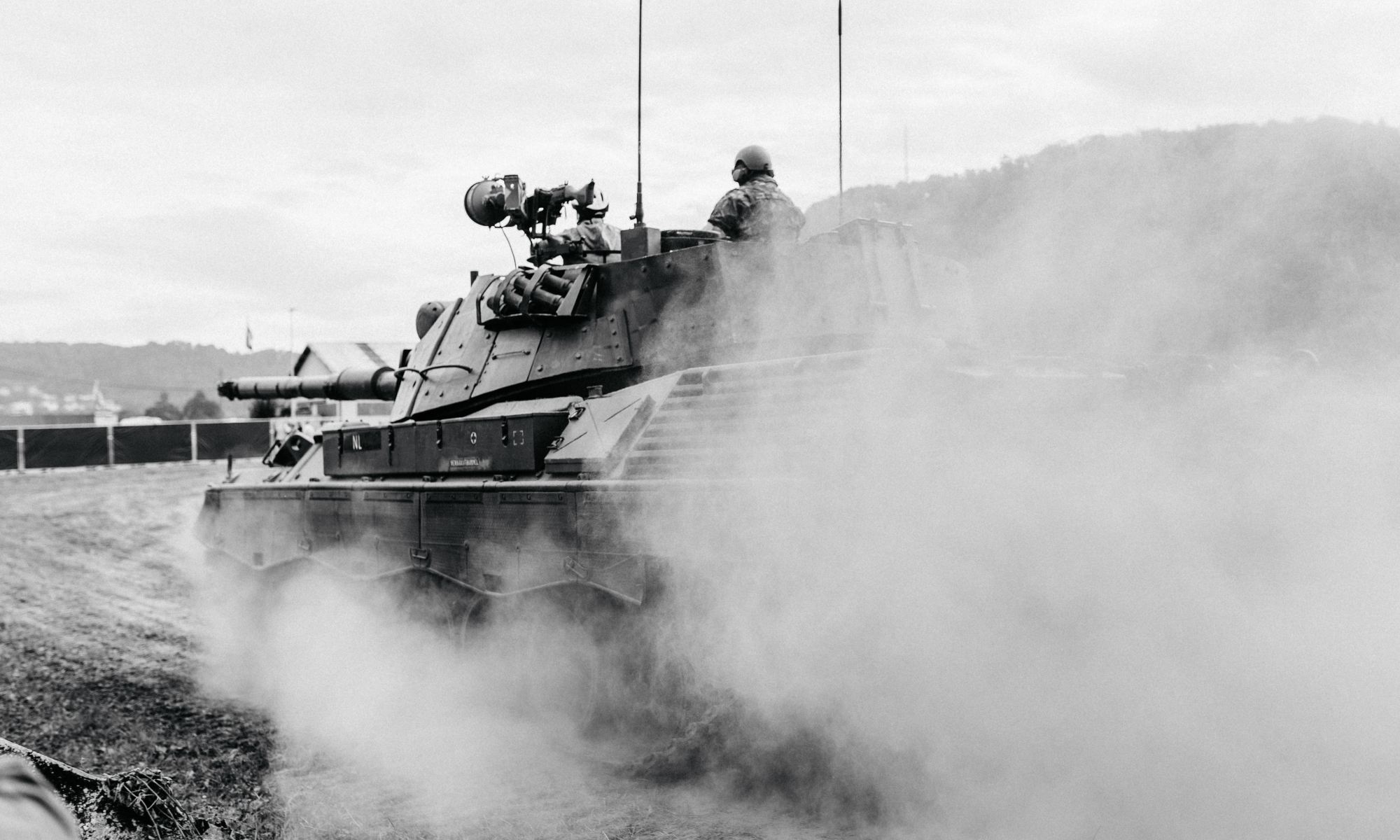 Grayscale photo of soldiers on a tank.