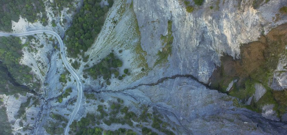 Bird's eye view of road beneath a mountain.