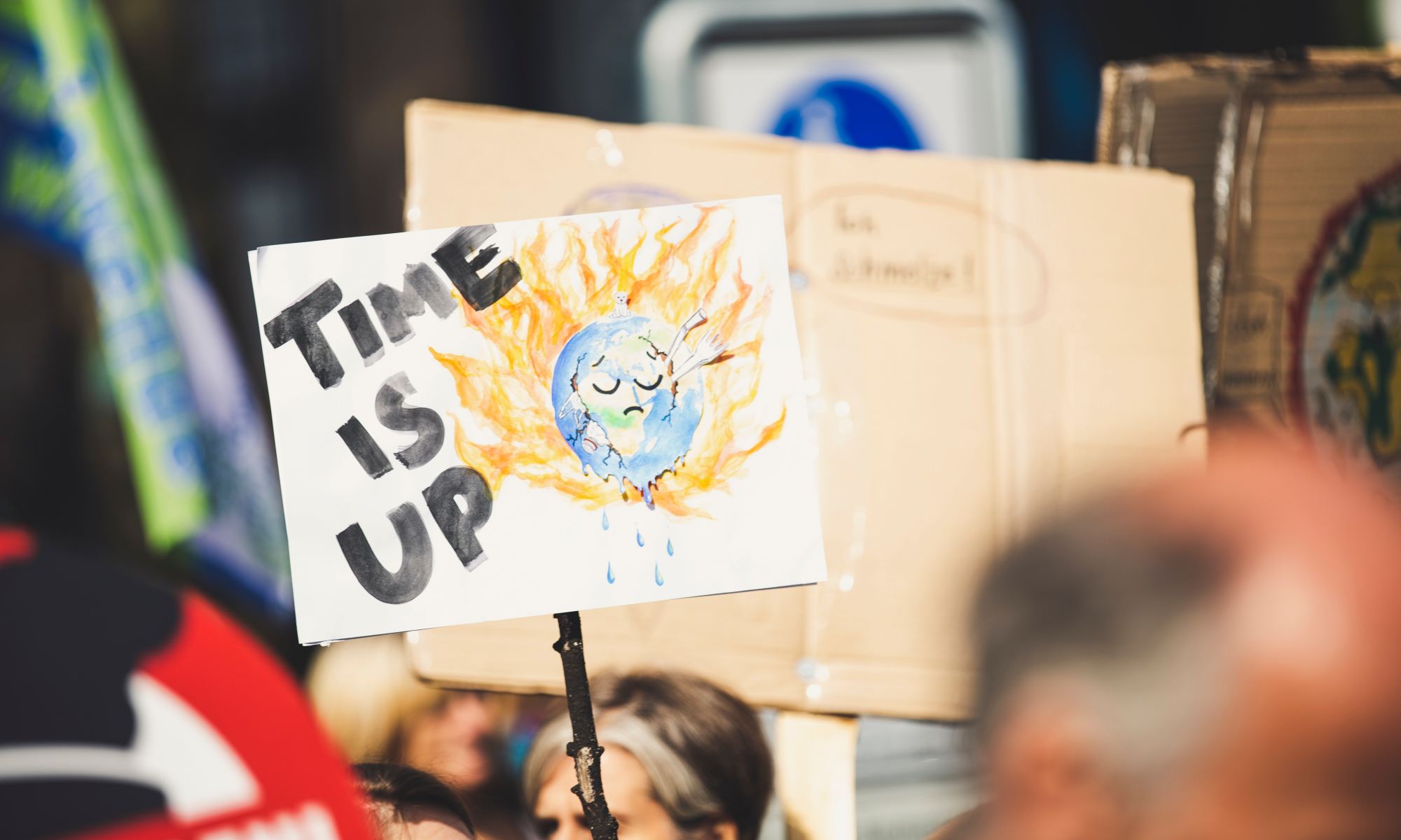 A sign at a climate protest that reads 'time is up'.